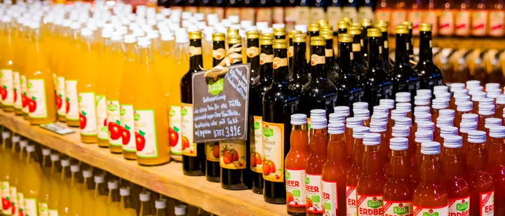 Unsere verschiedenen Produkte in Flaschen: Erdbeer-Nektar, Erdbeer-Sirup, Apfelsaft. Alles in unserem Bauernmarkt.